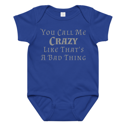"You Call Me Crazy Like That's A Bad Thing" printed on a royal baby jersey bodysuit laying on a flat surface amongst other clothes