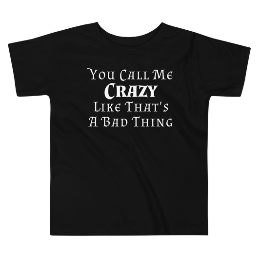 "You Call Me Crazy Like That's A Bad Thing" printed on a black toddler short sleeve tee laying on a flat surface