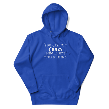 "You Call Me Crazy Like That's A Bad Thing" printed on a team royal unisex hoodie laying on a flat surface with the hood up