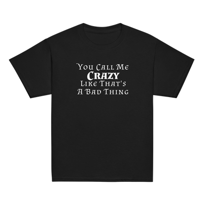 "You Call Me Crazy Like That's A Bad Thing" printed on a black youth classic tee laying on a flat surface