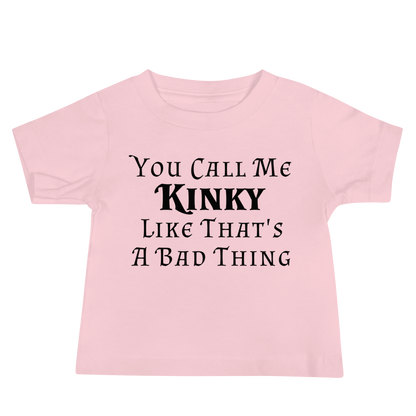 "You Call Me Kinky Like That's A Bad Thing" printed on a pink baby jersey short sleeve tee laying on a flat surface