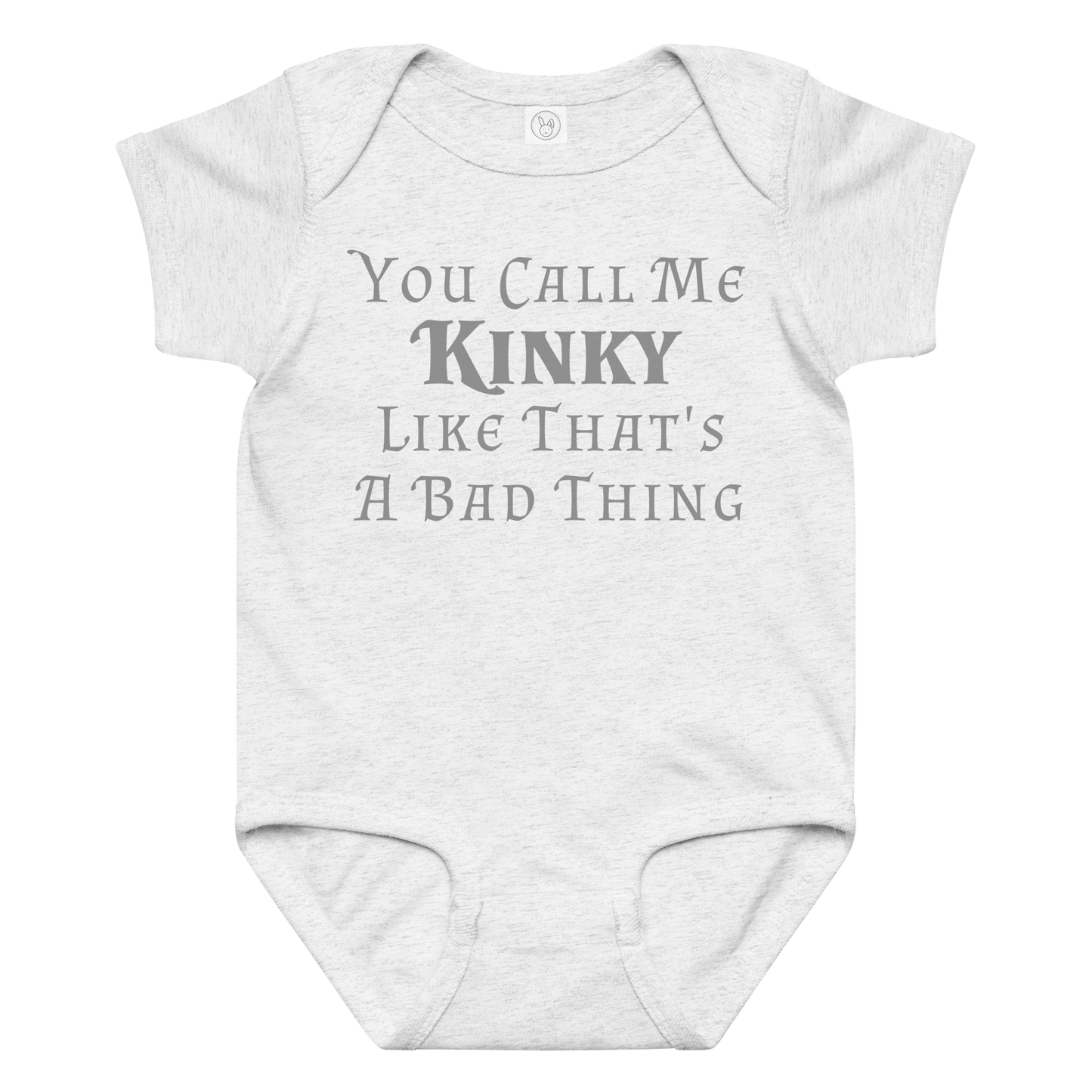 "You Call Me Kinky Like That's A Bad Thing" printed on a ash baby jersey bodysuit laying on a flat surface amongst other clothes