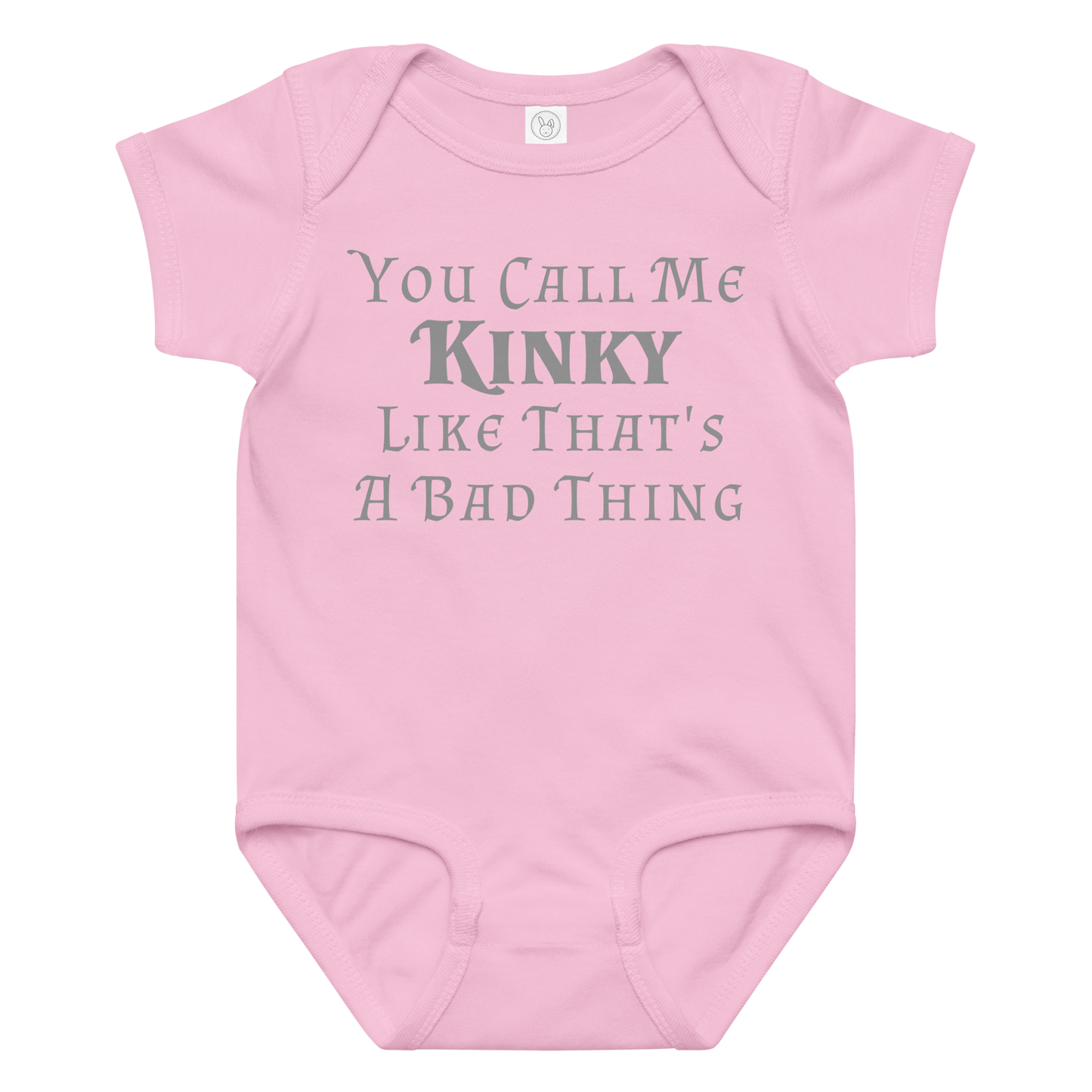 "You Call Me Kinky Like That's A Bad Thing" printed on a pink baby jersey bodysuit laying on a flat surface amongst other clothes