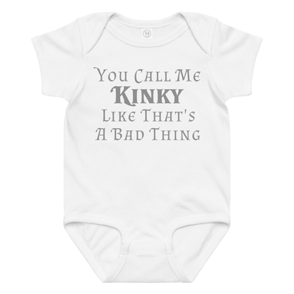 "You Call Me Kinky Like That's A Bad Thing" printed on a white baby jersey bodysuit laying on a flat surface amongst other clothes