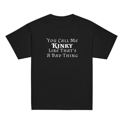 "You Call Me Kinky Like That's A Bad Thing" printed on a black youth classic tee laying on a flat surface