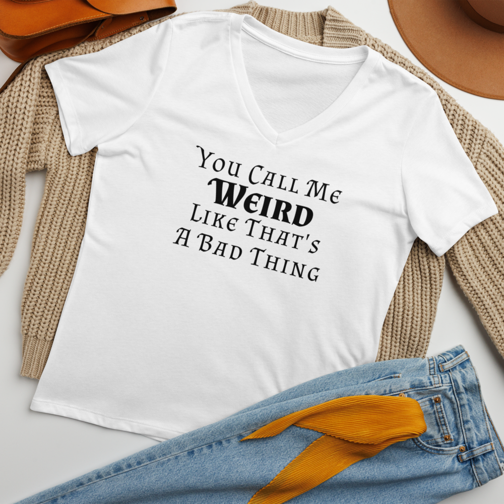 "You Call Me Weird Like That's A Bad Thing" printed on a solid white blend women's relaxed v-neck t-shirt laying on a flat surface amongst other clothes