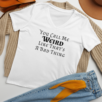 "You Call Me Weird Like That's A Bad Thing" printed on a solid white blend women's relaxed v-neck t-shirt laying on a flat surface amongst other clothes