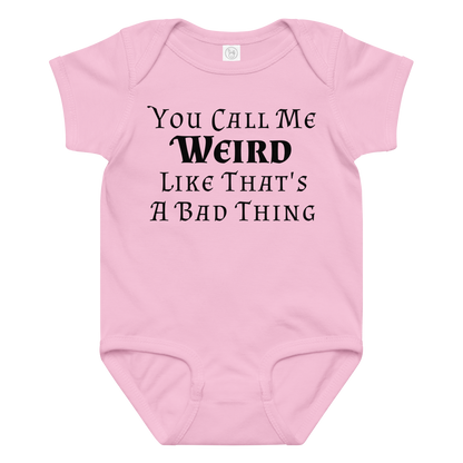 "You Call Me Weird Like That's A Bad Thing" printed on a pink baby jersey bodysuit laying on a flat surface amongst other clothes