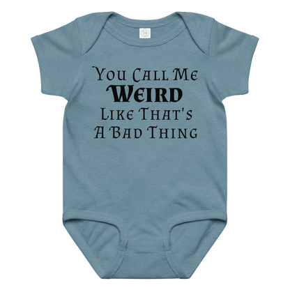 "You Call Me Weird Like That's A Bad Thing" printed on a vintage indigo baby jersey bodysuit laying on a flat surface amongst other clothes
