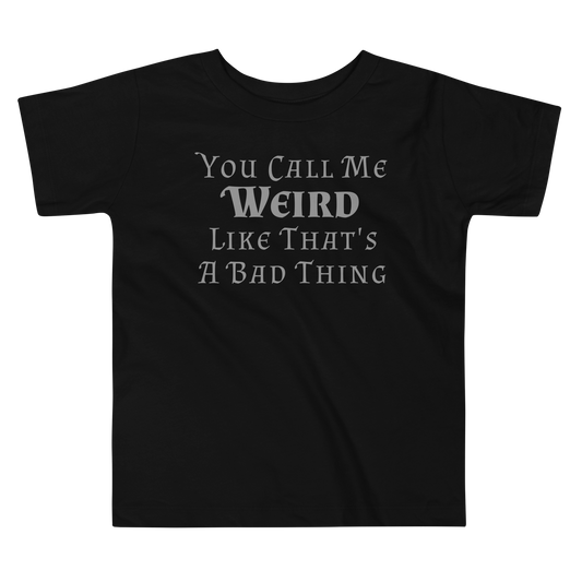 "You Call Me Weird Like That's A Bad Thing" printed on a black toddler short sleeve tee laying on a flat surface
