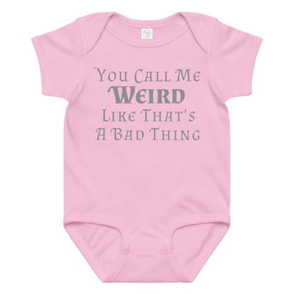 "You Call Me Weird Like That's A Bad Thing" printed on a pink baby jersey bodysuit laying on a flat surface amongst other clothes