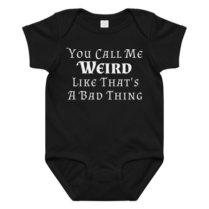 "You Call Me Weird Like That's A Bad Thing" printed on a black baby jersey bodysuit laying on a flat surface amongst other clothes