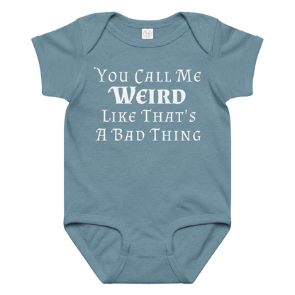 "You Call Me Weird Like That's A Bad Thing" printed on a vintage indigo baby jersey bodysuit laying on a flat surface amongst other clothes