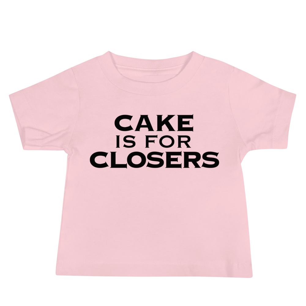 "Cake Is For Closers" printed on a pink baby jersey short sleeve tee laying on a flat surface