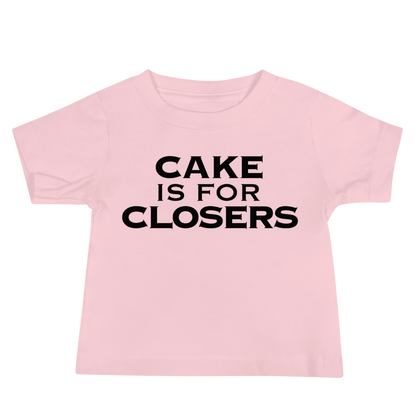 "Cake Is For Closers" printed on a pink baby jersey short sleeve tee laying on a flat surface