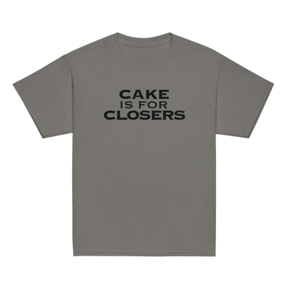 "Cake Is For Closers" printed on a charcoal youth classic tee laying on a flat surface