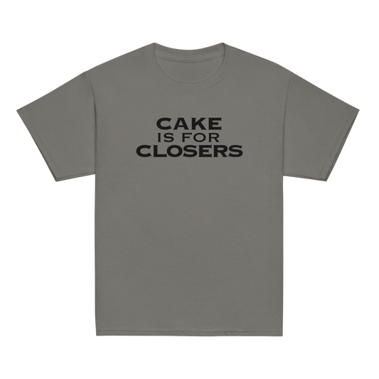 "Cake Is For Closers" printed on a charcoal youth classic tee laying on a flat surface