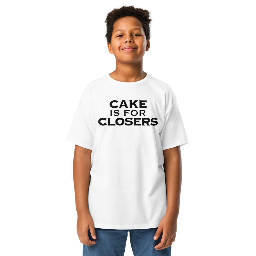 "Cake Is For Closers" printed on a white youth classic tee worn by a male