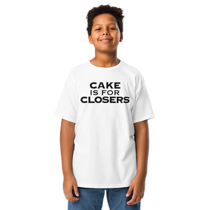 "Cake Is For Closers" printed on a white youth classic tee worn by a male