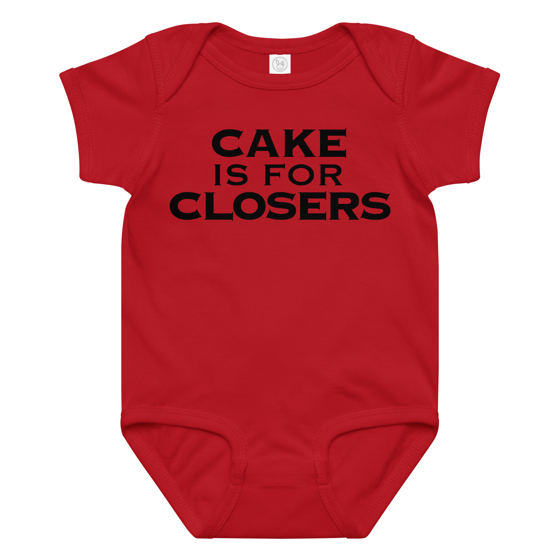 "Cake Is For Closers" printed on a red baby jersey bodysuit laying on a flat surface amongst other clothes