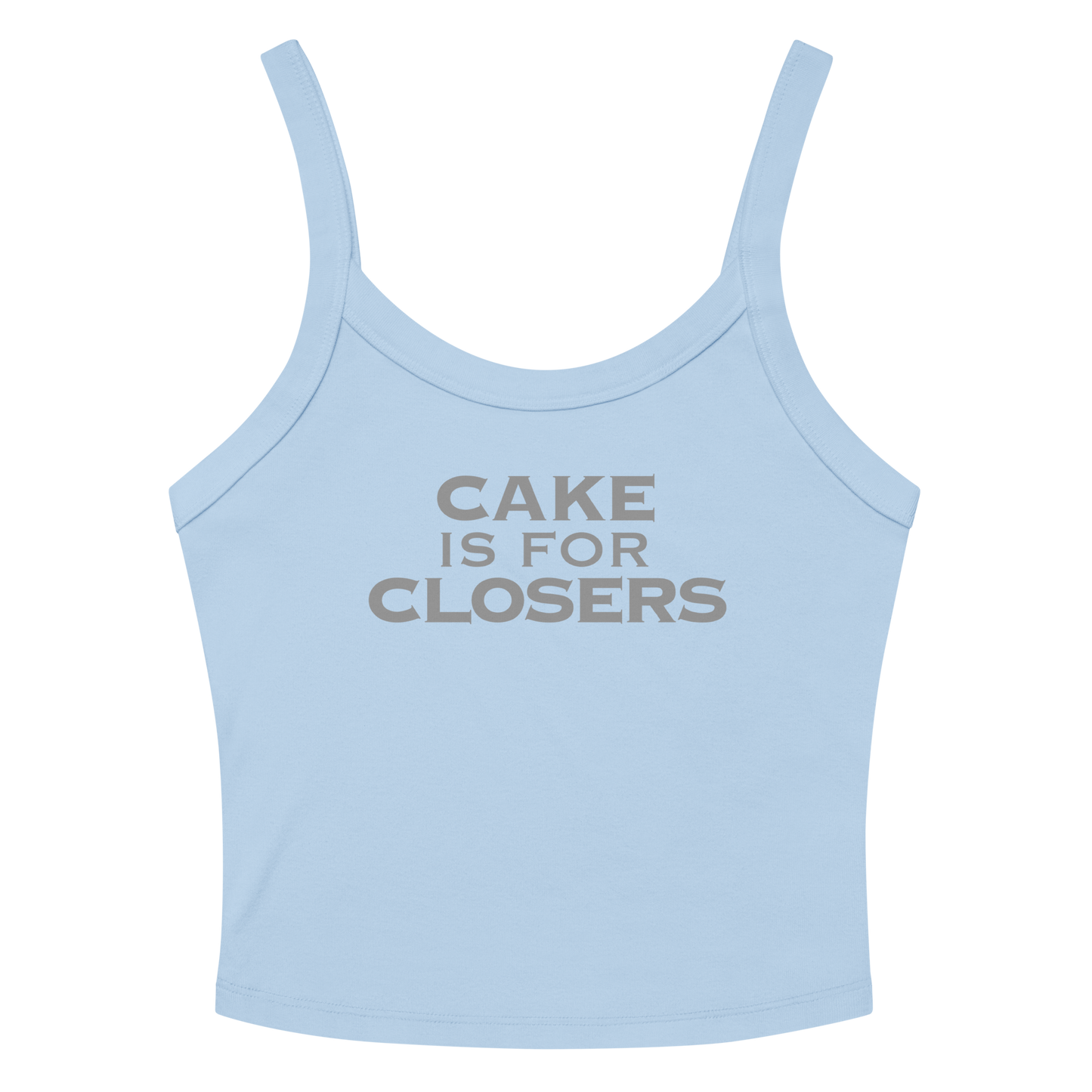 "Cake Is For Closers" printed on a solid baby blue blend women's micro-rib tanktop laying on a flat surface amongst sunglasses and shorts
