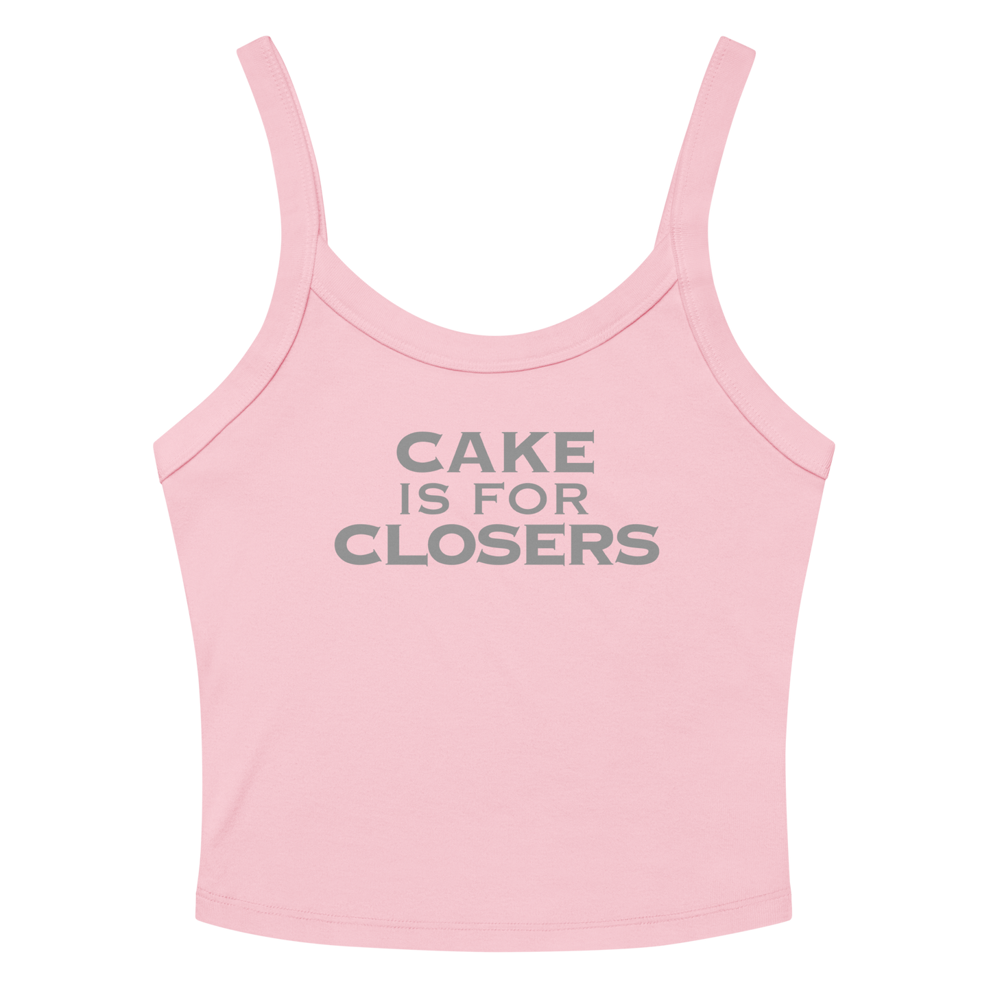 "Cake Is For Closers" printed on a solid pink blend women's micro-rib tanktop laying on a flat surface amongst sunglasses and shorts