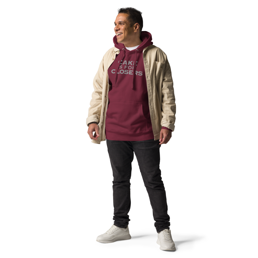 "Cake Is For Closers" printed on a maroon unisex hoodie worn by a male with a jacket on top