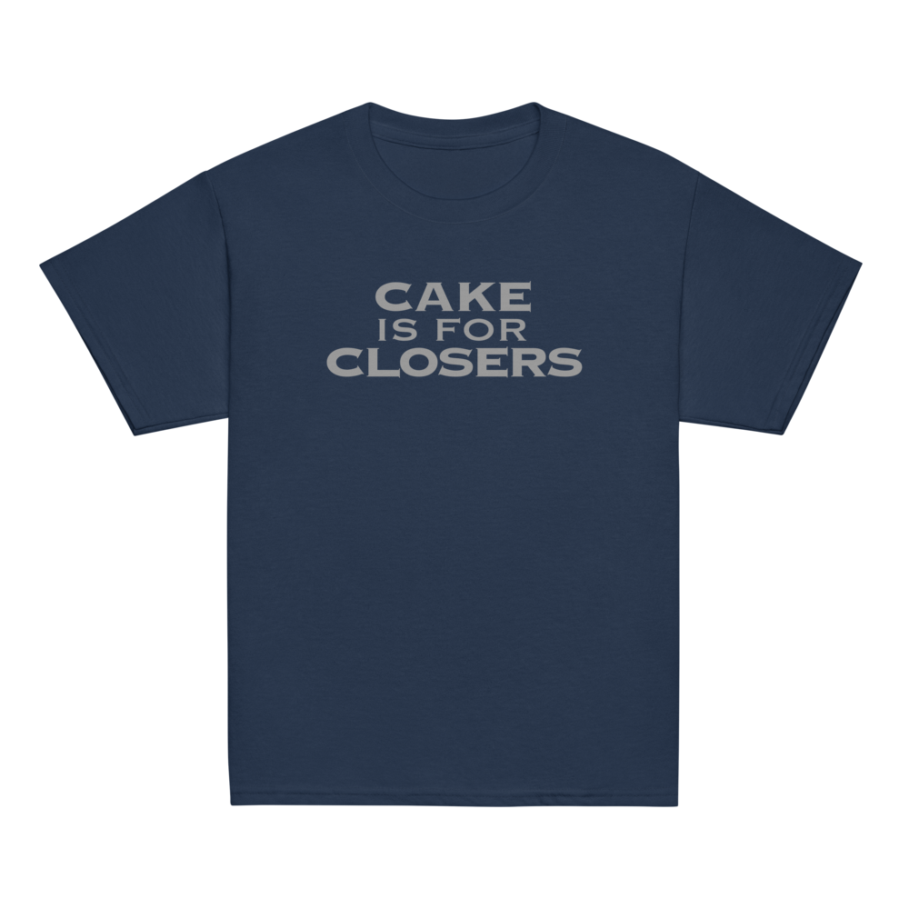 "Cake Is For Closers" printed on a navy youth classic tee laying on a flat surface