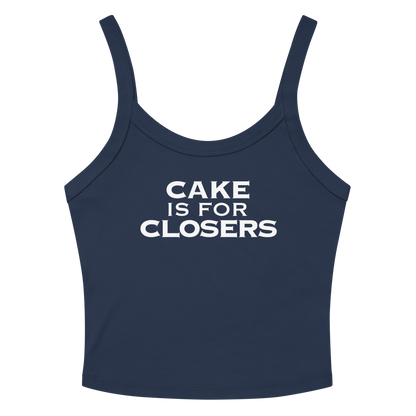"Cake Is For Closers" printed on a solid navy blend women's micro-rib tanktop laying on a flat surface amongst sunglasses and shorts
