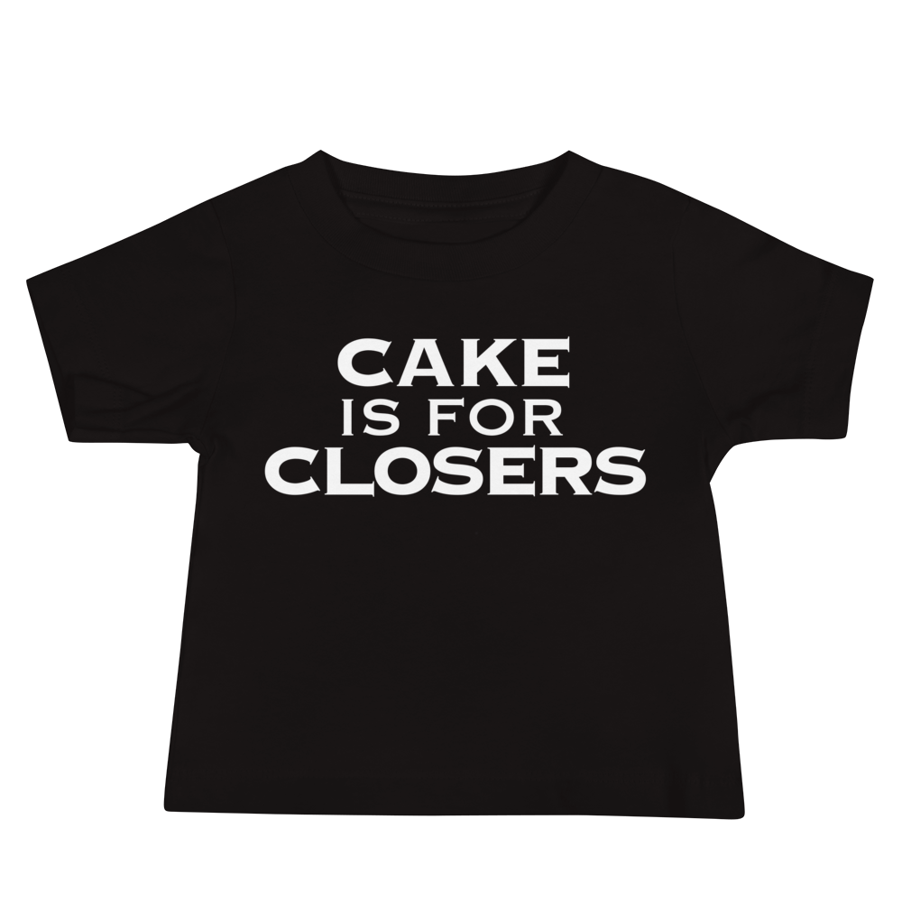 "Cake Is For Closers" printed on a black baby jersey short sleeve tee laying on a flat surface