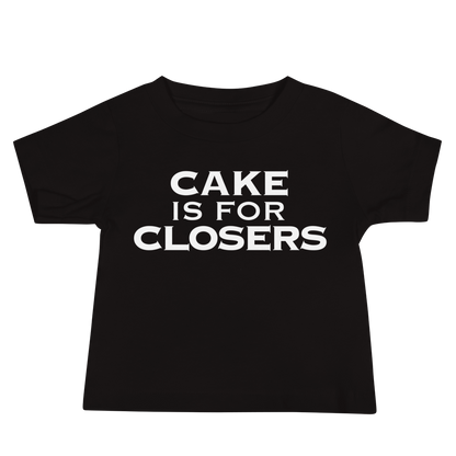 "Cake Is For Closers" printed on a black baby jersey short sleeve tee laying on a flat surface