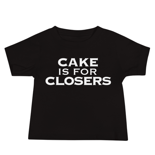 "Cake Is For Closers" printed on a black baby jersey short sleeve tee laying on a flat surface