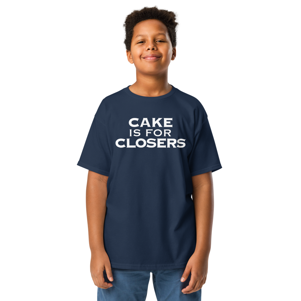 "Cake Is For Closers" printed on a navy youth classic tee worn by a male