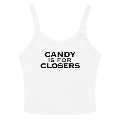 "Candy Is For Closers" printed on a solid white blend women's micro-rib tanktop laying on a flat surface amongst sunglasses and shorts