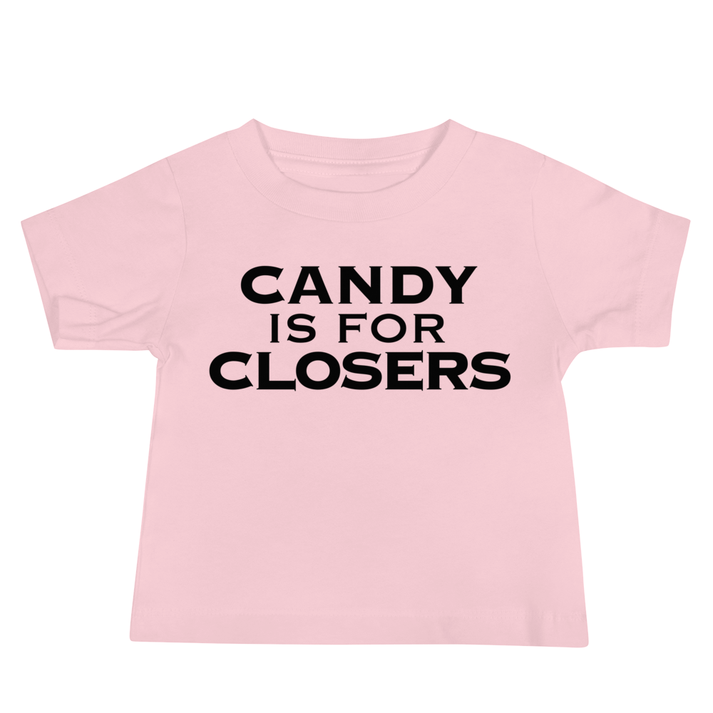 "Candy Is For Closers" printed on a pink baby jersey short sleeve tee laying on a flat surface