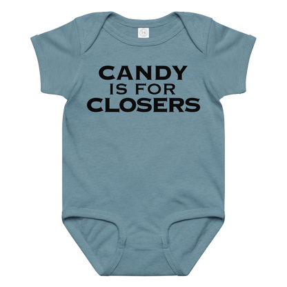"Candy Is For Closers" printed on a vintage indigo baby jersey bodysuit laying on a flat surface amongst other clothes
