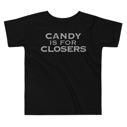 "Candy Is For Closers" printed on a black toddler short sleeve tee laying on a flat surface