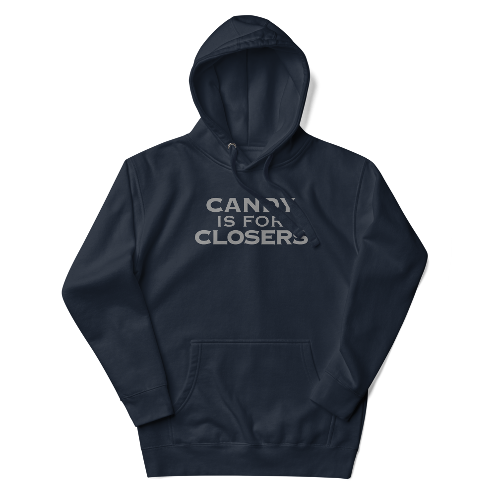 "Candy Is For Closers" printed on a navy blazer unisex hoodie laying on a flat surface with the hood up