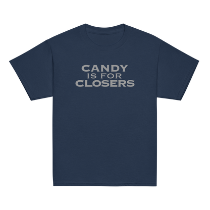 "Candy Is For Closers" printed on a navy youth classic tee laying on a flat surface