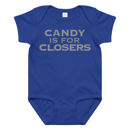"Candy Is For Closers" printed on a royal baby jersey bodysuit laying on a flat surface amongst other clothes