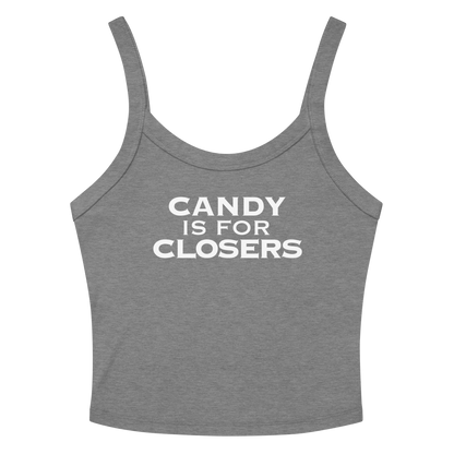 "Candy Is For Closers" printed on a athletic heather women's micro-rib tanktop laying on a flat surface amongst sunglasses and shorts