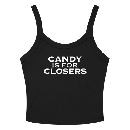 "Candy Is For Closers" printed on a solid black blend women's micro-rib tanktop laying on a flat surface amongst sunglasses and shorts