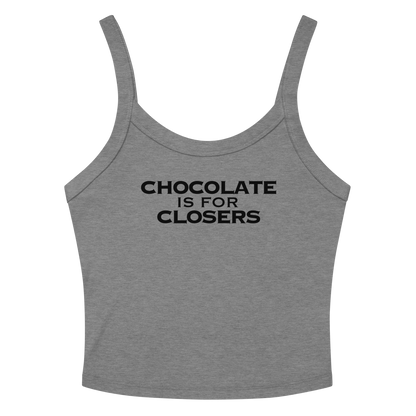 "Chocolate Is For Closers" printed on a athletic heather women's micro-rib tanktop laying on a flat surface amongst sunglasses and shorts