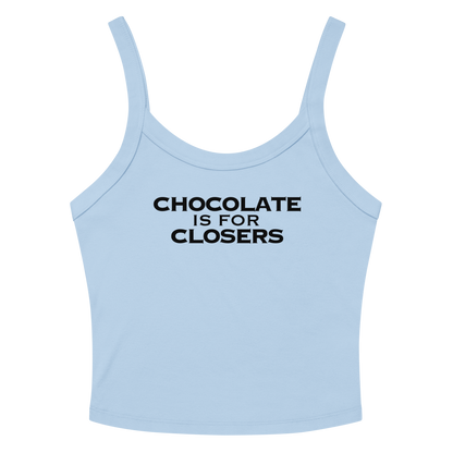 "Chocolate Is For Closers" printed on a solid baby blue blend women's micro-rib tanktop laying on a flat surface amongst sunglasses and shorts