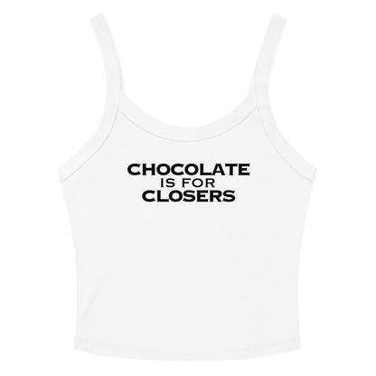 "Chocolate Is For Closers" printed on a solid white blend women's micro-rib tanktop laying on a flat surface amongst sunglasses and shorts