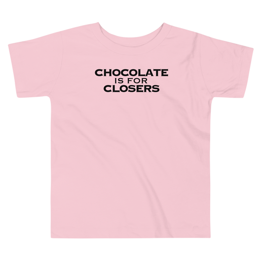 "Chocolate Is For Closers" printed on a pink toddler short sleeve tee laying on a flat surface