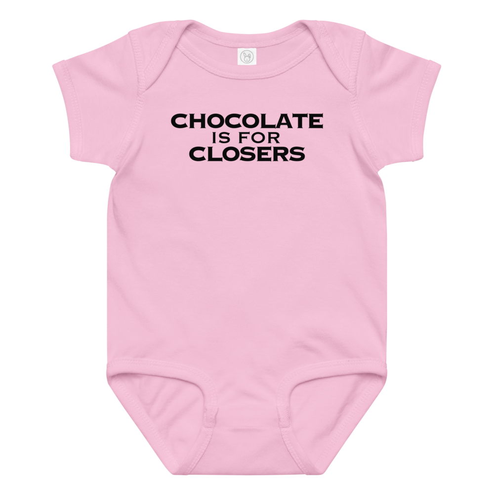 "Chocolate Is For Closers" printed on a pink baby jersey bodysuit laying on a flat surface amongst other clothes