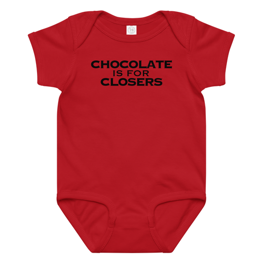 "Chocolate Is For Closers" printed on a red baby jersey bodysuit laying on a flat surface amongst other clothes