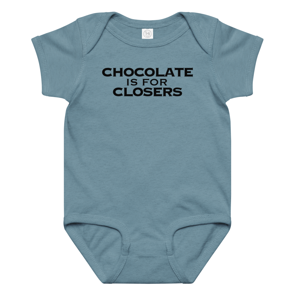 "Chocolate Is For Closers" printed on a vintage indigo baby jersey bodysuit laying on a flat surface amongst other clothes