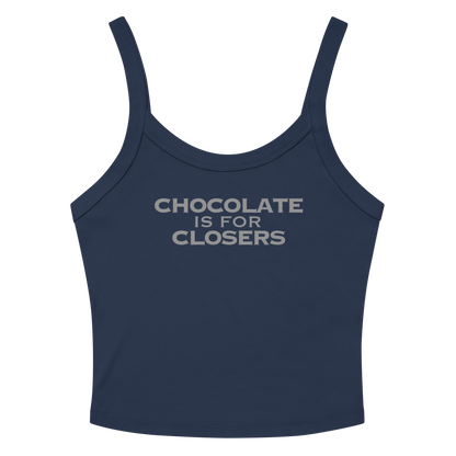 "Chocolate Is For Closers" printed on a solid navy blend women's micro-rib tanktop laying on a flat surface amongst sunglasses and shorts